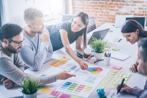 group of team memebers discussing a client's project around a table in an office setting