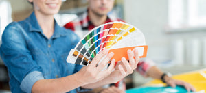 woman holding pantone chart talking to client